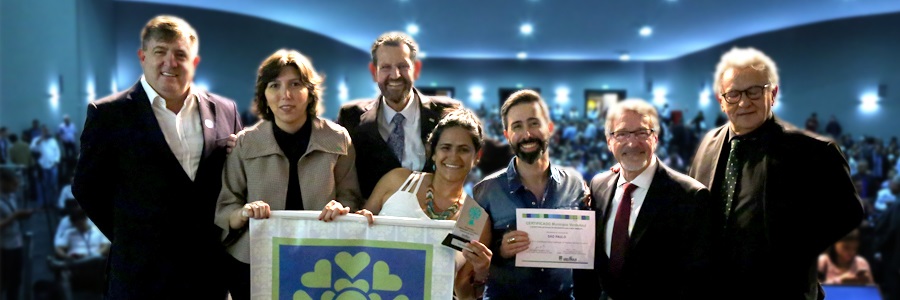 No auditório do Governo do Estado, Secretário do Verde e do Meio Ambiente, e membros da SVMA recebem prêmio em um fundo azull